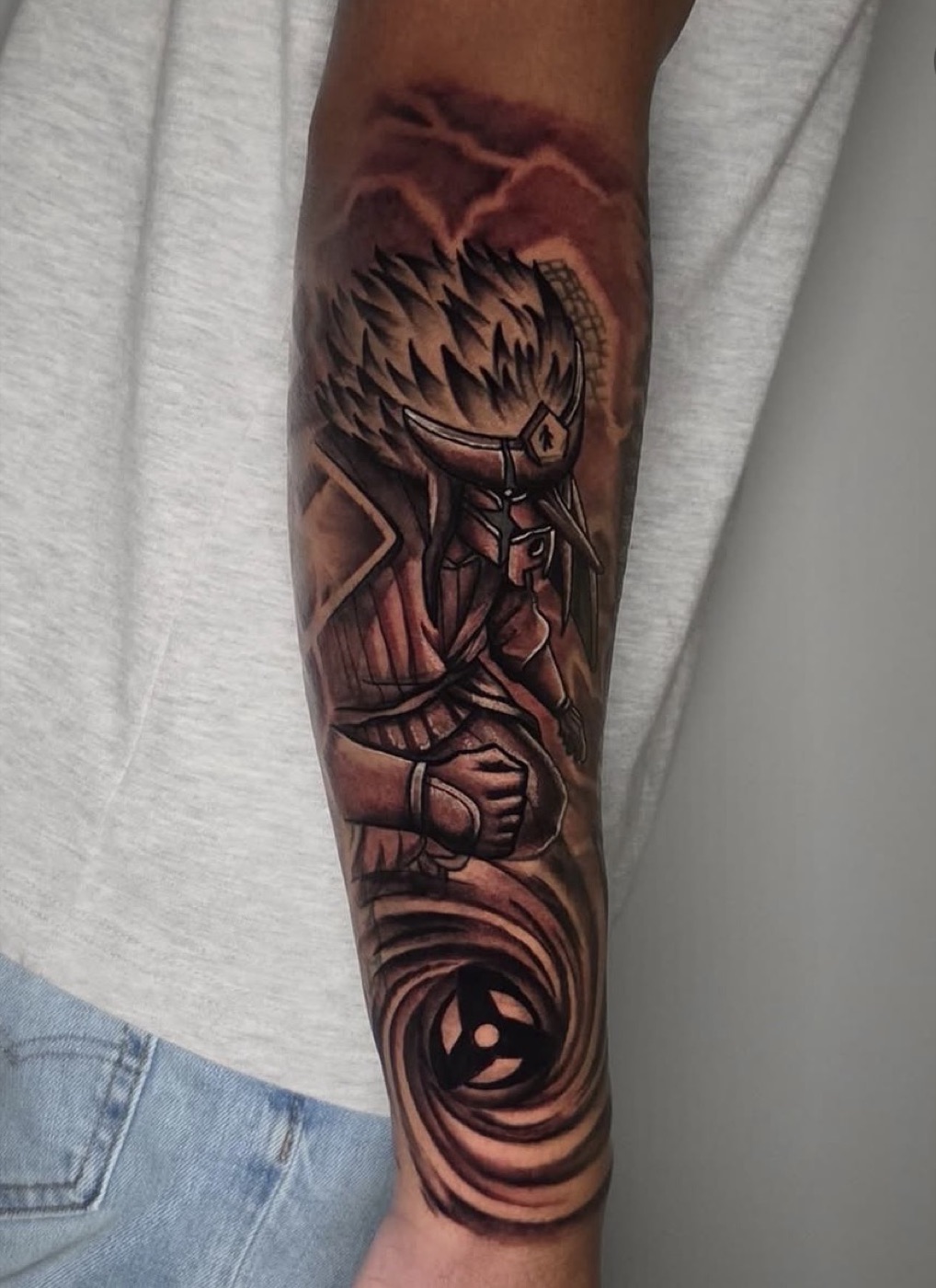 Color and black and grey anime-style character tattoo with a swirling vortex, forearm
